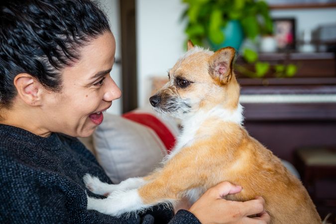 Woman smiling into the face of a cute small dog