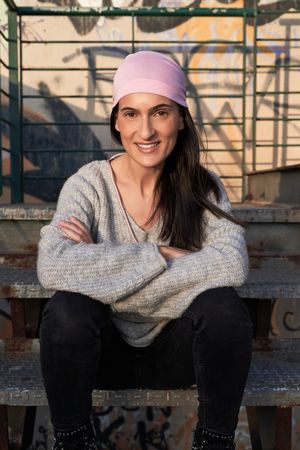 Smiling woman in pink scarf in grunge environment