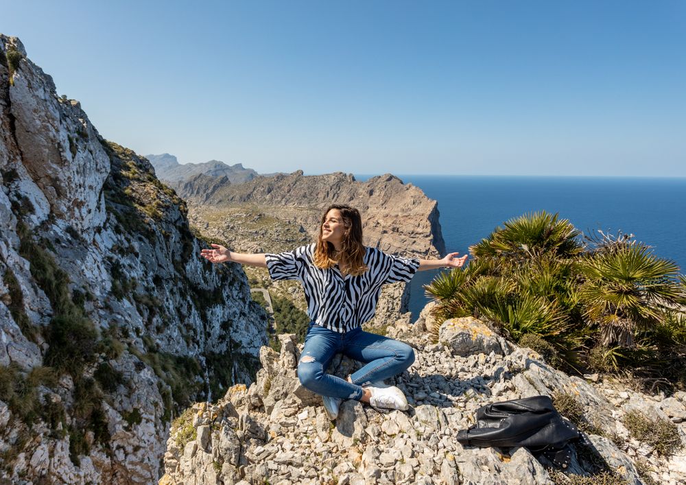 Young woman sitting on cliff