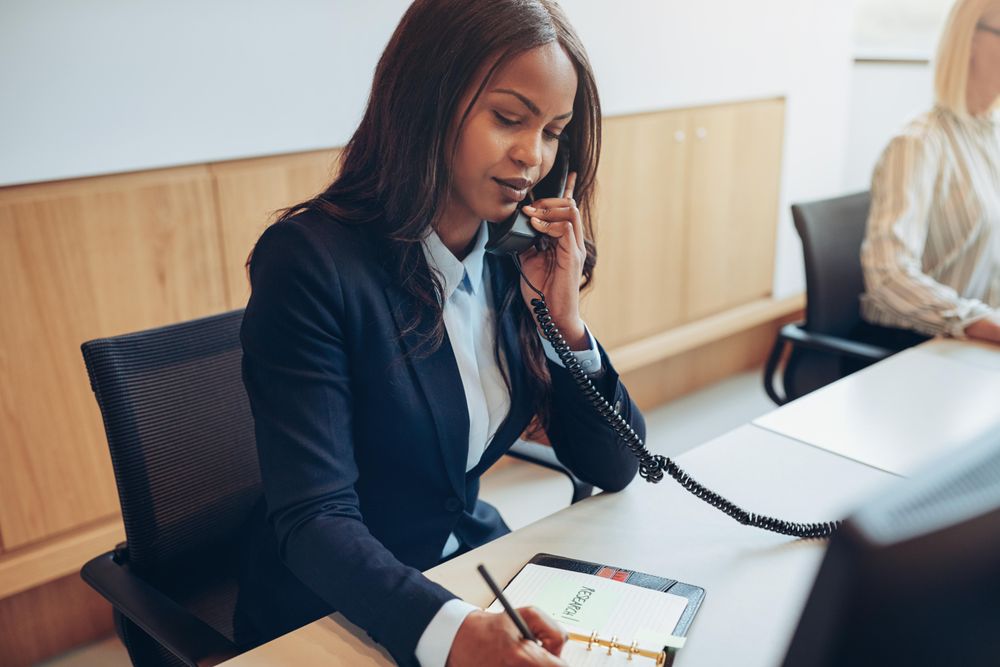 Woman sitting on the phone and taking notes