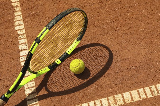 Tennis racquet and tennis ball on clay court