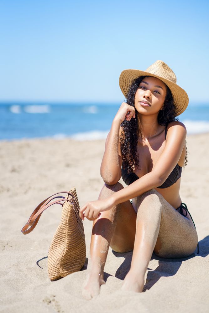 Enjoying a Relaxing Day at the Beach while Wearing a Sun Hat and Carrying a Stylish Tote Bag