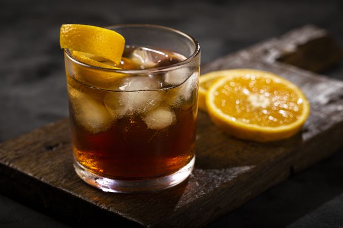 Negroni cocktail with orange, on dark background.