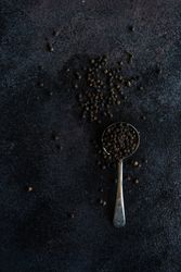 Measurement spoon filled with peppercorns