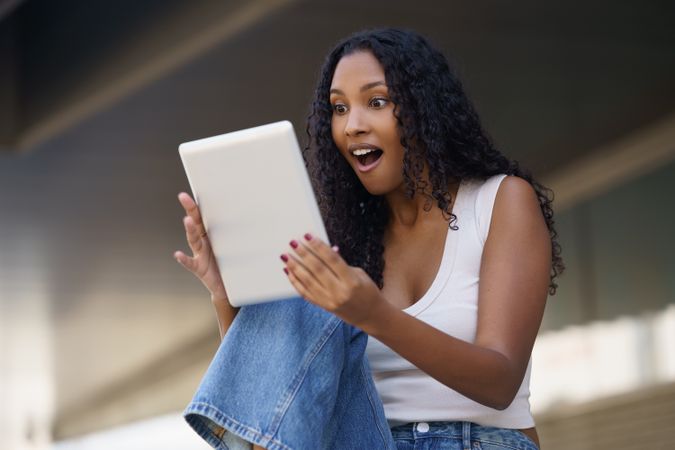 An Excited Young Woman Happily Discovering Something New on Her Tablet Device Today