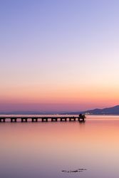 Anonymous tourists on pier during sundown