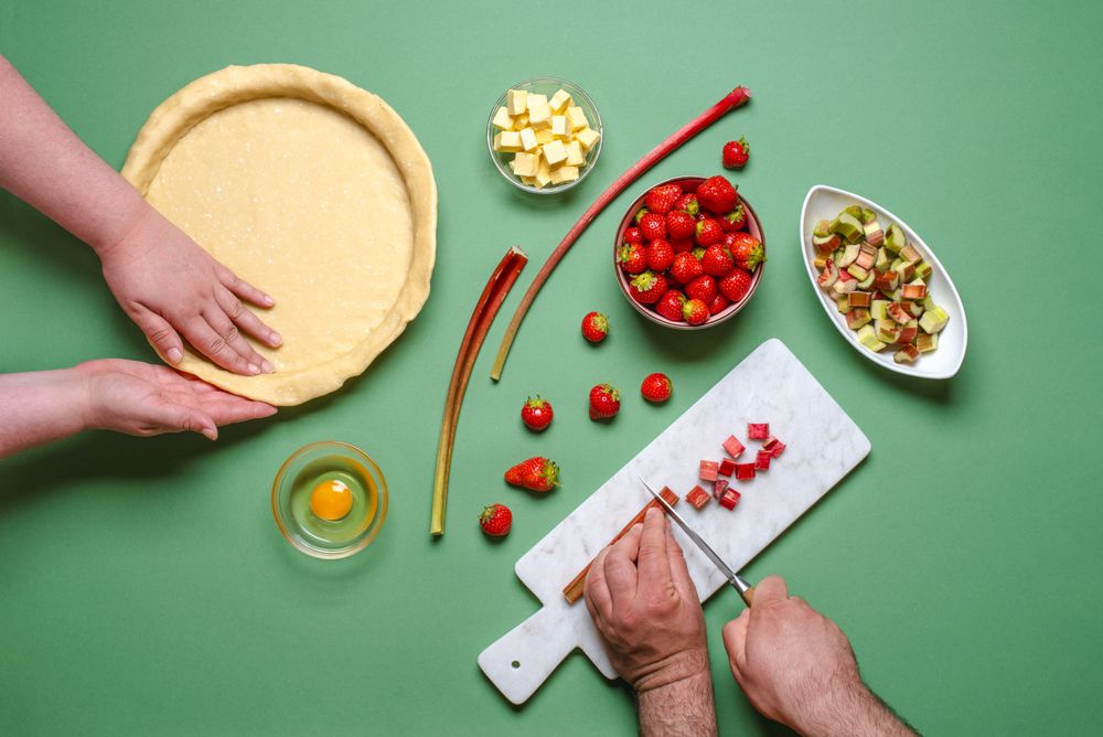Overhead of young couple home baking a rhubarb pie