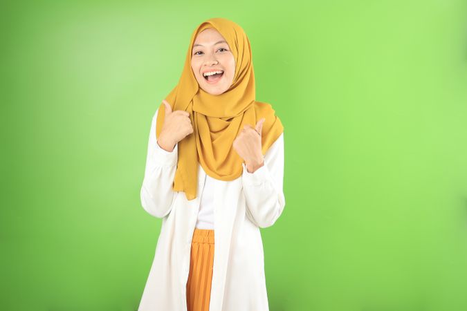 Young Asian Muslim Woman Smiling and Making Thumbs Up  Gesture