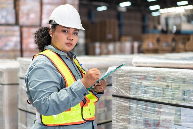 Woman in safety gear working in warehouse