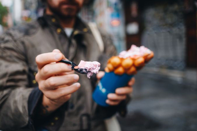 Man eating spoon of ice cream from bubble waffle