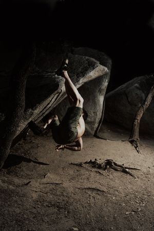 Man practicing rock climbing among large rocks in a forest