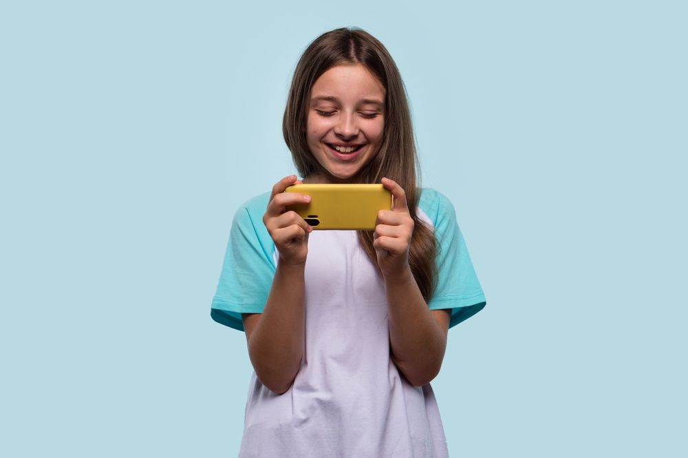 Girl enjoys using phone, immersed in playful moment.