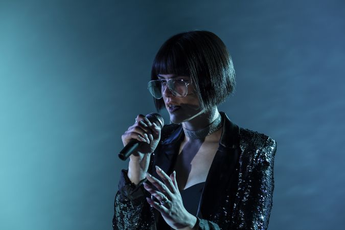 Stylish woman singing on stage
