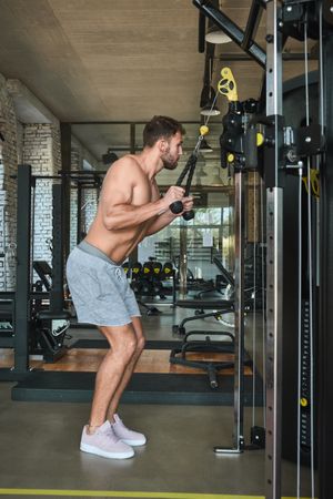 Guy using exercise machine in gym