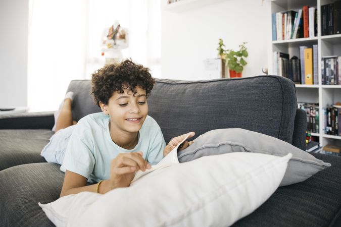 Girl reading a book on a sofa