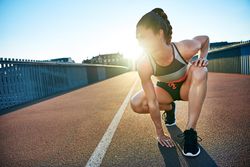 Fit woman crouched down before workout