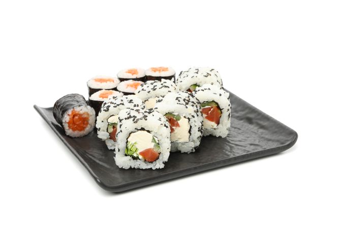 Tray with delicious sushi rolls isolated on light background