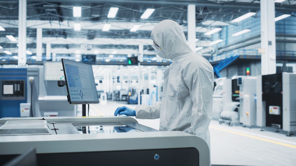 Unrecognizable person in protective gear working in front of screen in store