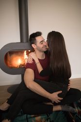 Couple sitting near fireplace on floor