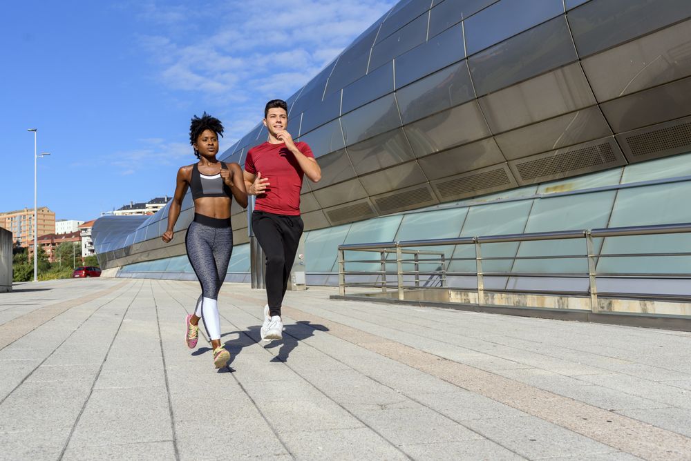 Modern active sportspeople running in city
