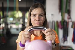 A woman performs exercises holding the kettlebell