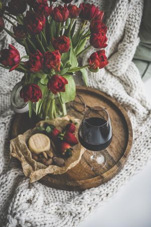 Wine and snacks with flowers, top view