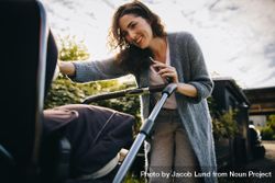 Smiling mother adoring her baby fastened in a stroller 5nx12b