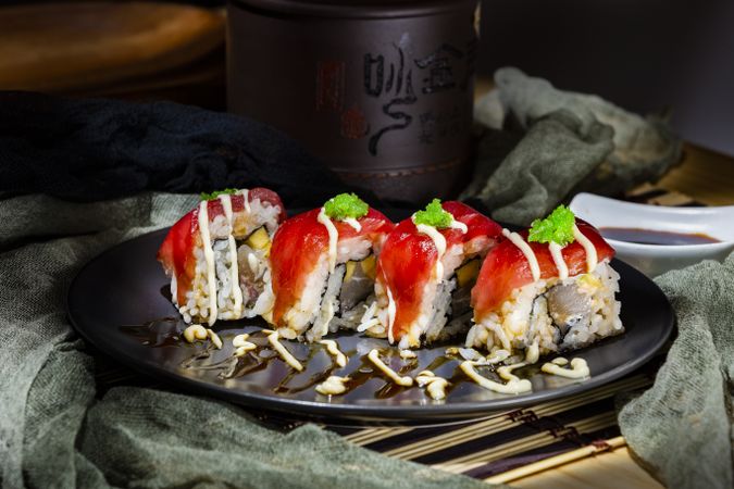 Tasty sushi covered with tuna and sauce on plate