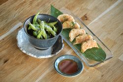 Dumplings placed on table near edamame and soy sauce