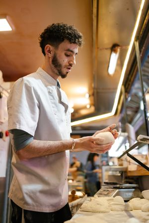 Pizza man kneading in bakery