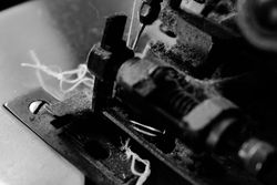 B&W shot of string through sewing machine needle