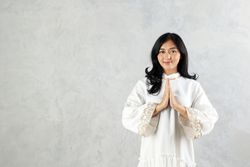 Female Asian Muslim Wearing Abaya Gesturing Eid Mubarak Greeting