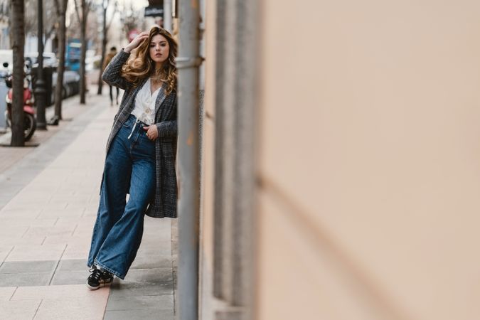 Woman leaning on wall on street
