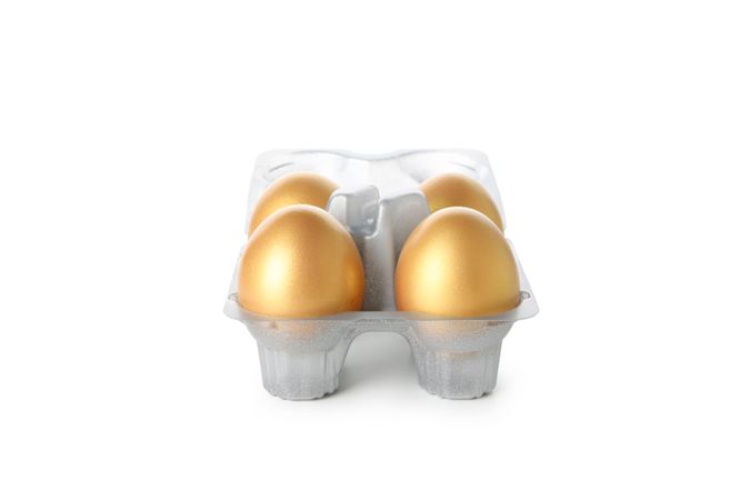 Concept of Richness, golden eggs, isolated on plain background