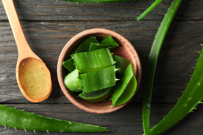 Aloe vera leaves and slices on wooden table, closeup and top view. Natural treatment