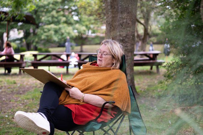 Relaxed woman drawing in park