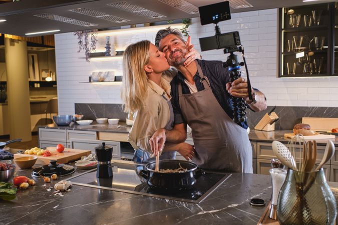 Wife kissing husband while taking selfie