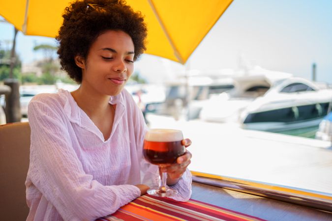 Woman with glass of beer at cafe on the waterfront