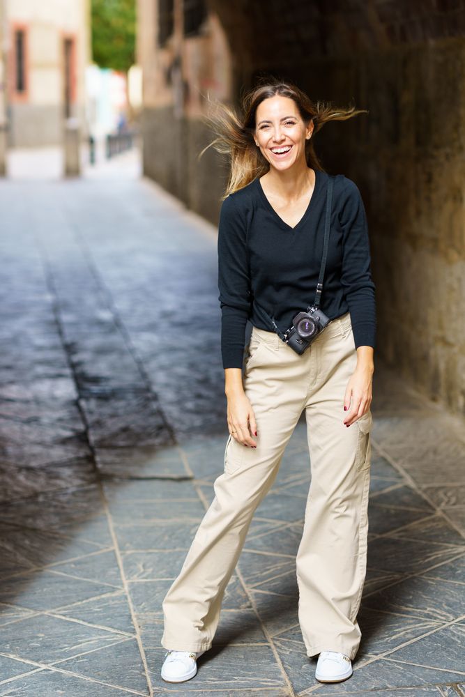 Happy woman with camera in arch