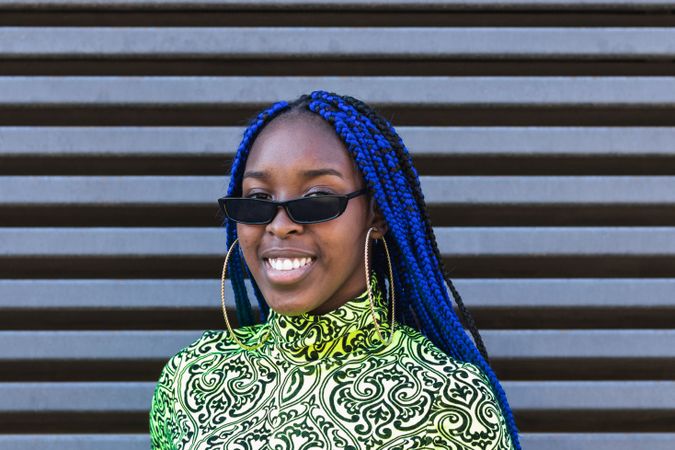 Smiling Black woman in trendy clothes in city