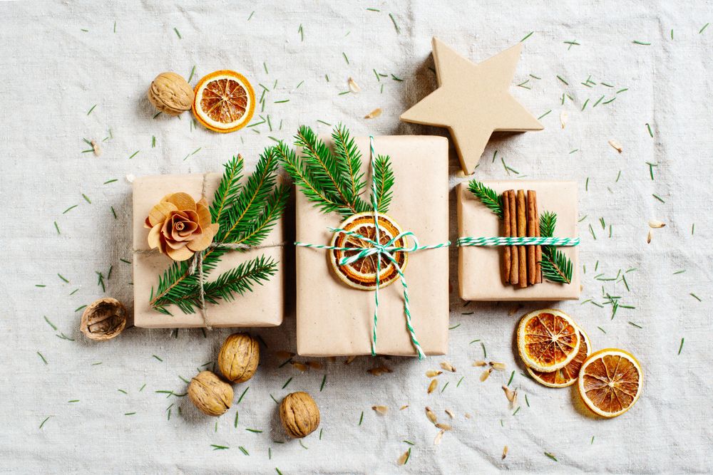 Top view of natural colored gift wrapped boxes with dried oranges and cinnamon sticks