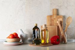 Kitchen table with different supplies and bottles with oil