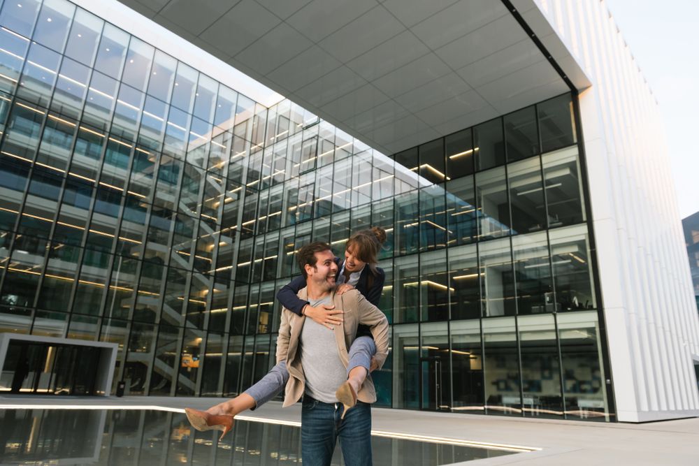 Cheerful couple having fun and hugging on street in downtown