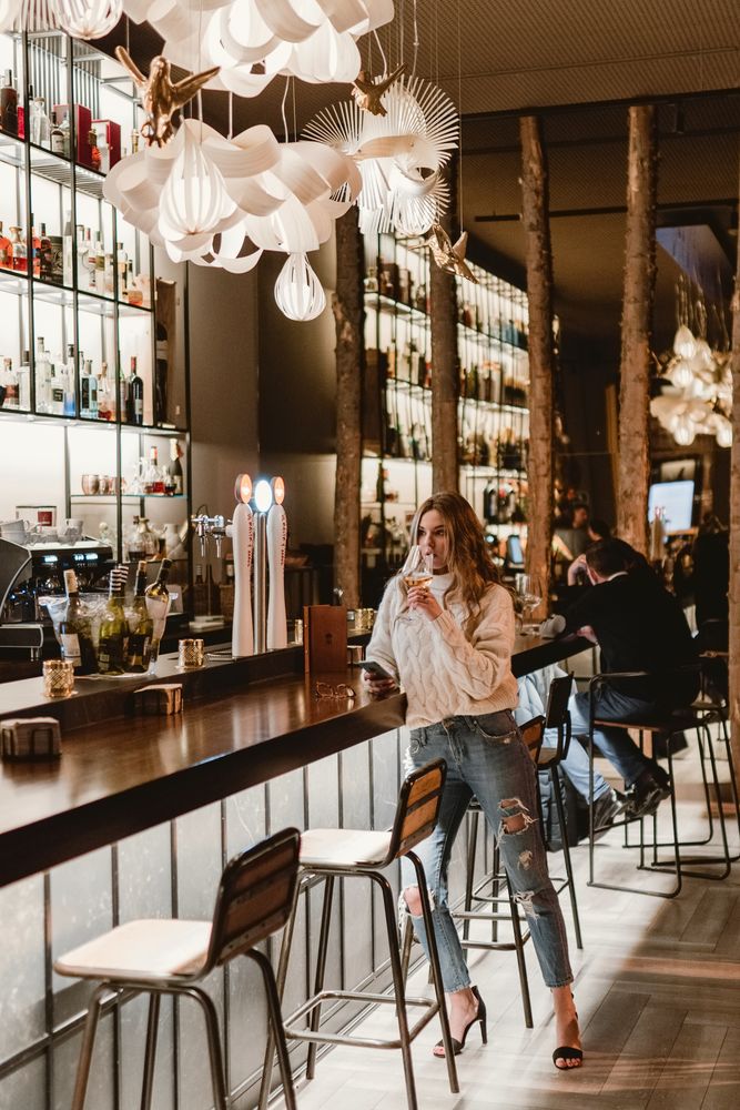 Stylish woman drinking wine in bar