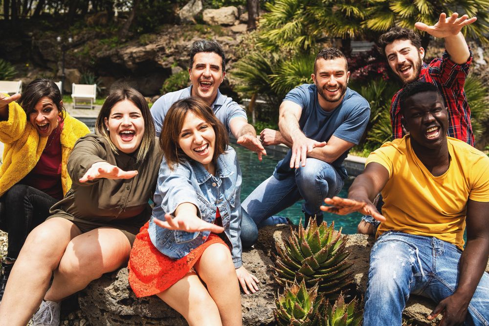 Joyful multi-ethnic diverse group of young people having fun together posing looking at the camera