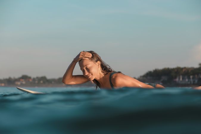 woman on surf board floating on water