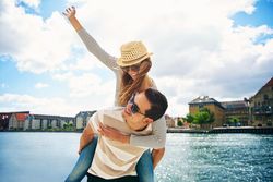 Happy fun couple with woman on man’s back both smiling