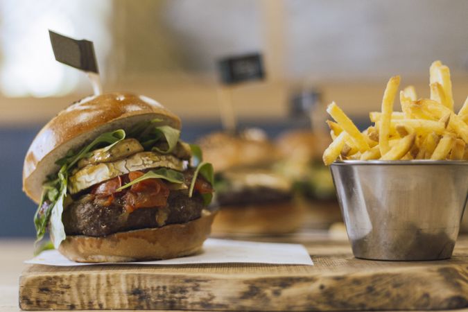 Juicy delicious burger and fried potato on table