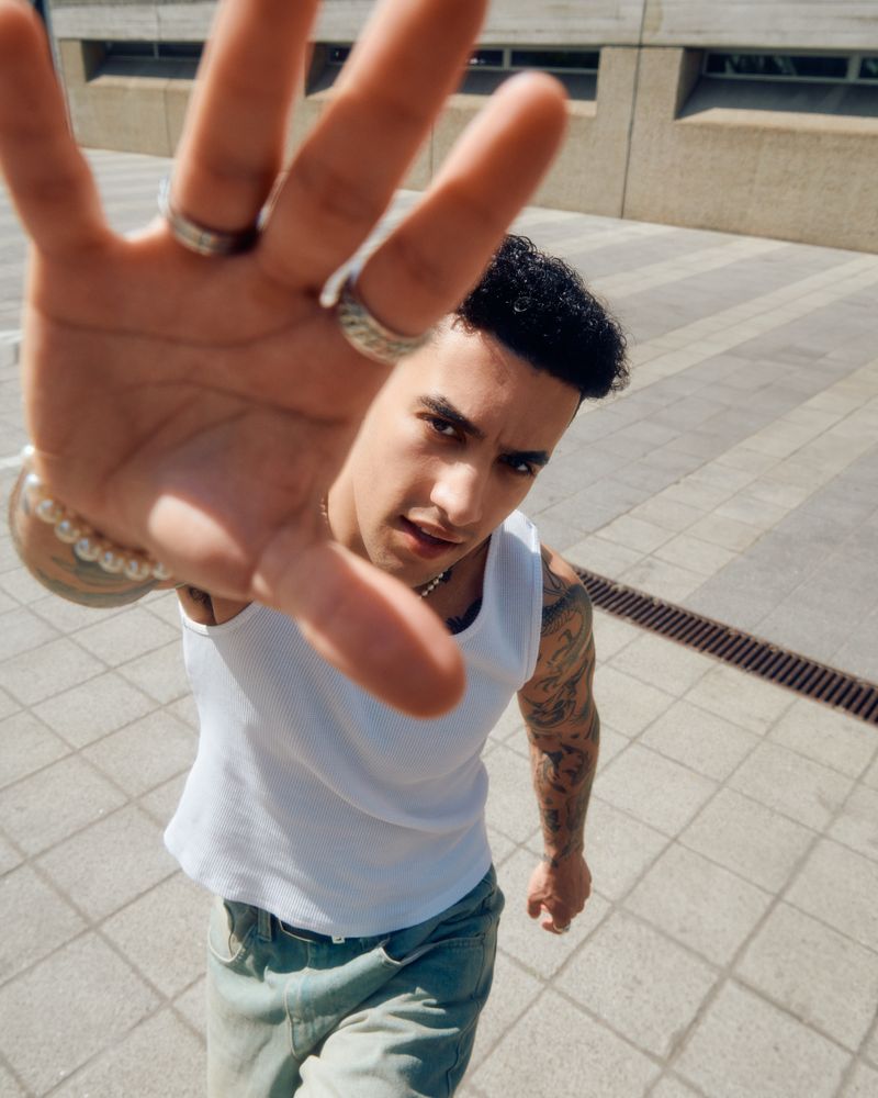 Man in vest reaching for camera