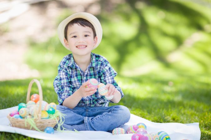 Baby Boy Outside Wearing Rabbit Ears Playing with Easter Eggs